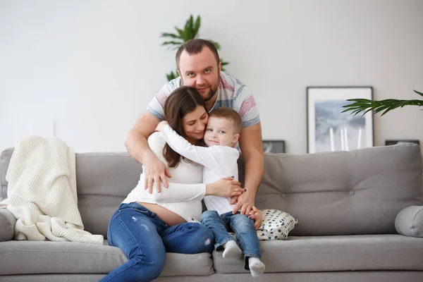 Foto de família feliz com filho no sofá cinza — Fotografia de Stock