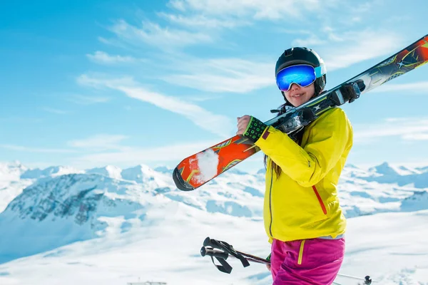 Image of girl wearing helmet, mask with skis on her shoulder — Stock Photo, Image