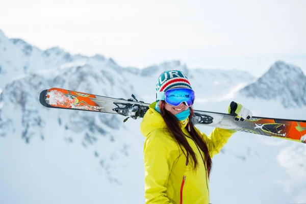 Karlı tepe çerçevede omzuna kayaklar ile sporcu kadın fotoğrafı — Stok fotoğraf