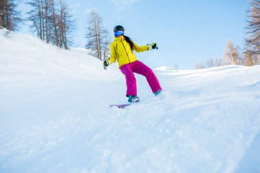 Spor kadın giyiyor kask ve snowboard maskeden ağaçları ile karlı yamaç fotoğrafı