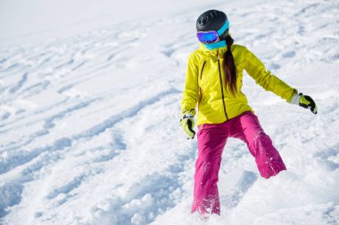 Kadın esmer giyen kask ve maske, karlı dağ yamacı snowboard fotoğrafı