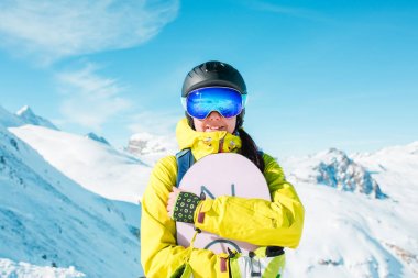 Miğfer ve karlı tepelerin arka planı snowboard sportif kadın resim