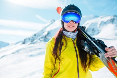 Miğfer, omzuna kayaklar maskeyle spor kızın resmi