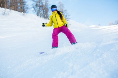 Spor kadın kask ve ağaçları ile karlı yamaç snowboard maskeden görüntüsünü