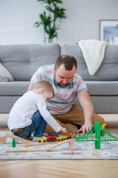 Imagem de homem e menino brincando na estrada de brinquedo — Fotografia de Stock