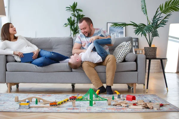 Imagem do pai estragando com o filho sentado no sofá — Fotografia de Stock