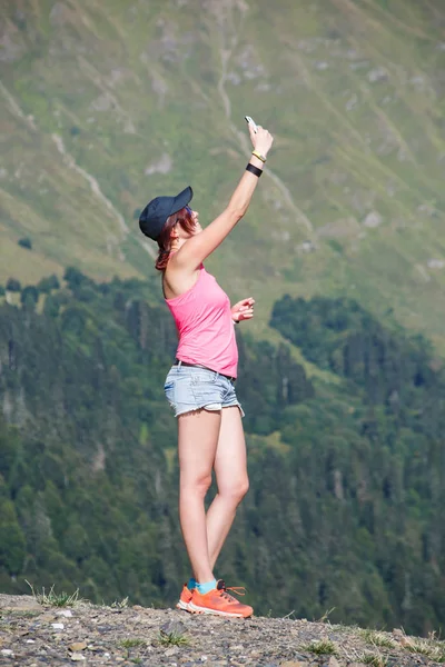 Foto de menina tirando fotos de si mesma contra montanhas — Fotografia de Stock