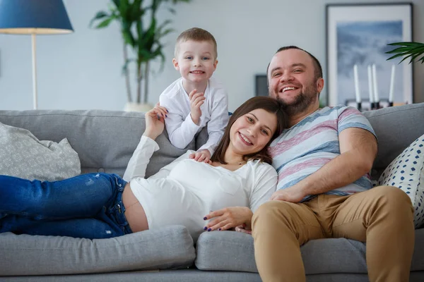 Foto de padres felices con su hijo pequeño en el sofá — Foto de Stock