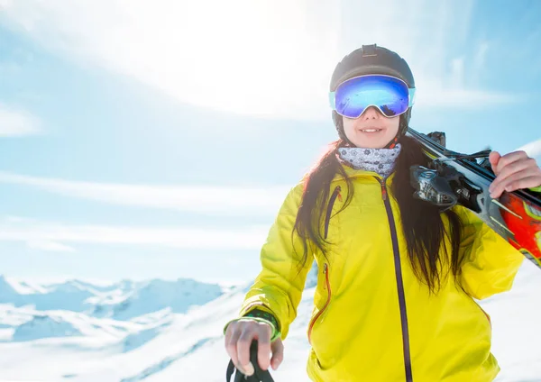 Photo of sports girl wearing helmet, a mask with skis on her shoulder — Stock Photo, Image