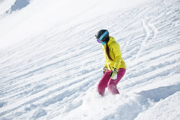 Picture of athlete brunette in helmet and mask, snowboarding from snowy mountain slope — Stock Photo, Image