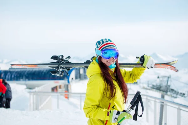 Foto van lachende sport vrouw met ski's op haar schouder — Stockfoto