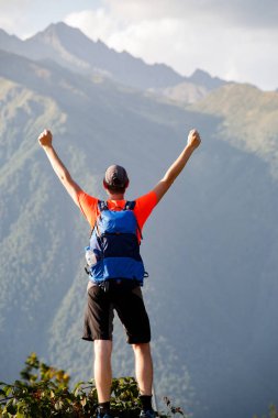 Adam sırt çantası ile eller yukarı ile arka üzerinden fotoğraf