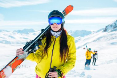Image of girl looking at camera wearing helmet, mask with skis clipart