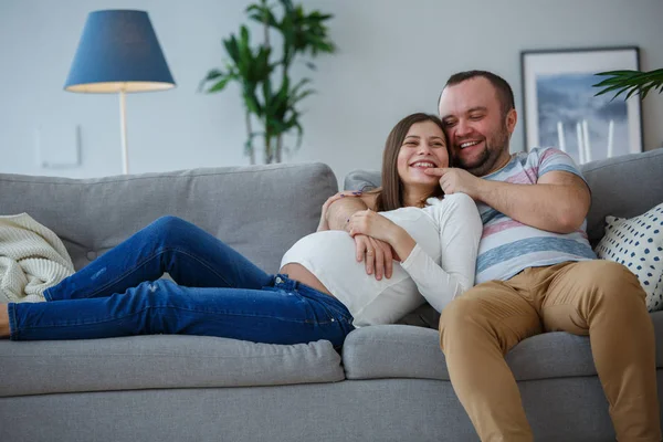 Bild von glücklichen Eheleuten auf grauem Sofa — Stockfoto