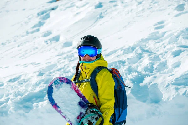 Imagen de mujer sonriente en casco y con snowboard sobre fondo de paisaje nevado —  Fotos de Stock