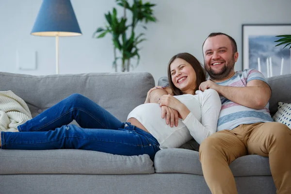 Foto von glücklichen Eheleuten auf grauem Sofa — Stockfoto