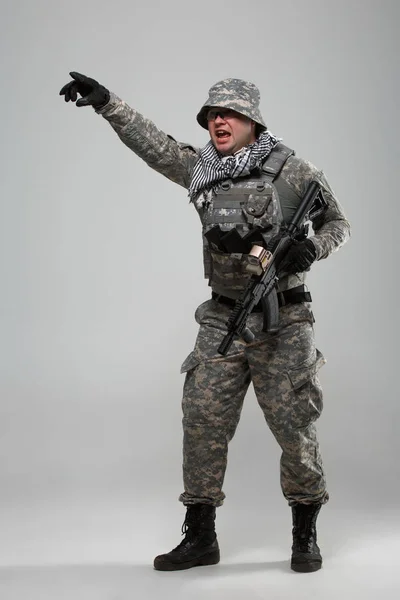 Full-length picture of military man in helmet with hand pointing — Stock Photo, Image