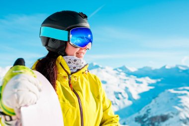 Gülümseyen kadın kask ve maske ile snowboard karlı tepelerin arka plan görüntü
