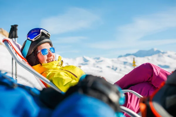 Изображение улыбающейся спортивной женщины лежащей на зимнем шезлонге — стоковое фото