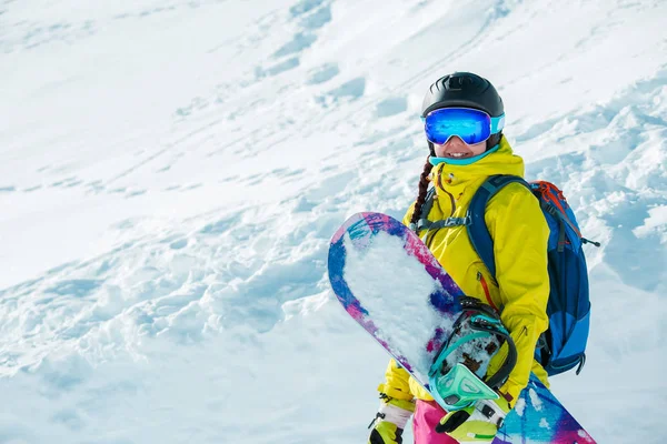 ヘルメットと雪の風景の背景とスノーボード笑顔の女の子の画像 — ストック写真