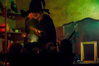 Görüntü siyah şapka okuma büyü pot yeşil buhar üzerinde cadı