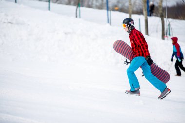 Snowboard karlı resort üzerinde yürüme ile sportif adam görüntüsünü