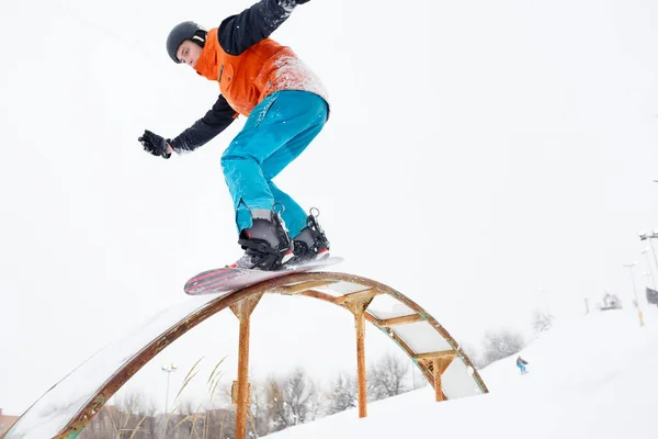 Photo of sportive man skiing on snowboard with springboard — Stock Photo, Image