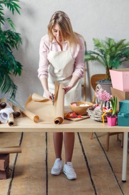 Kadın çiçekçi masaya buket oluşturma.