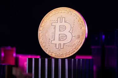 Fotoğraf işlemci pembe bir arka plan üzerinde sanal para, bitcoin ve