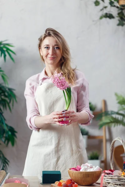 Imagem da florista mulher no avental no quarto com flores — Fotografia de Stock