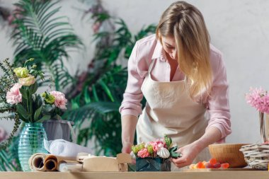 Photo of blonde florist making bouquet of marshmallows, flowers clipart