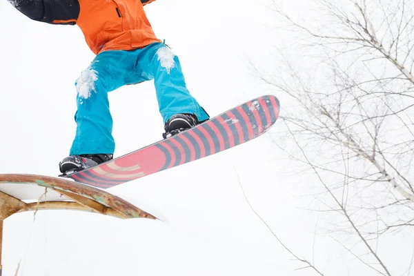 Foto van de onderkant van de sportieve mens skiën op snowboard met Springplank — Stockfoto