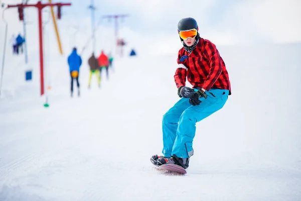 Zdjęcie sportowca z snowboard, jazda konna w ośrodku snowy — Zdjęcie stockowe