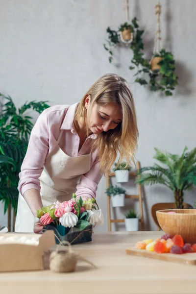 Image of florist composing bouquet at table on background of flowers — Stock Photo, Image