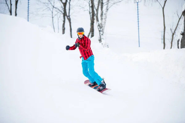 Image d'un snowboarder sportif chevauchant sur une colline enneigée — Photo