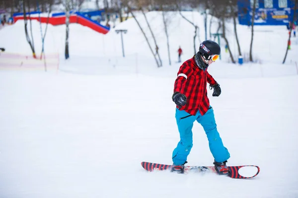 Photo d'athlète avec snowboard en station enneigée — Photo