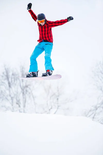 Sportos férfi snowboardos Ugrás a havas hegy képe — Stock Fotó