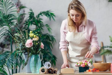 Çiçekçide çalışan profesyonel çiçekçi.