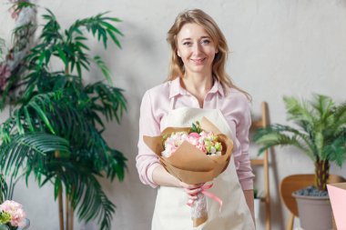Buket çiçek kraft kağıt ile önlük gülümseyen çiçekçi resmiyle