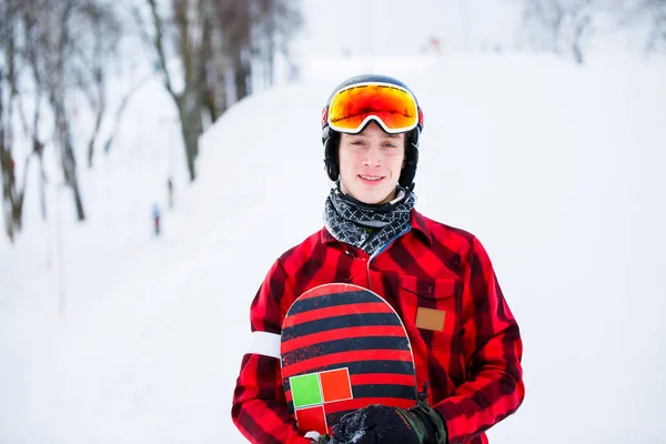 Foto de atleta en casco con snowboard sobre fondo borroso — Foto de Stock