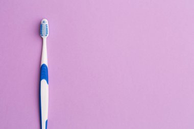 Boş pembe bir arka plan üzerinde diş fırçası
