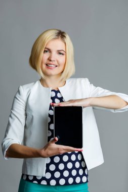 Tablet tutan gülümseyen genç kadın