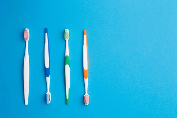 Multi-colored toothbrushes on blue background — Stock Photo, Image