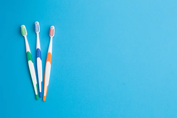 Toothbrushes at empty blue background — Stock Photo, Image
