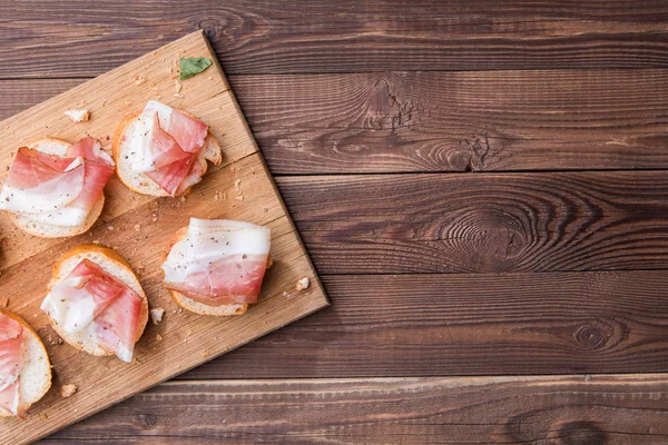 Bread and bacon, wooden board — Stock Photo, Image