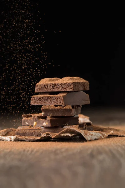 Broken chocolate on wooden table — Stock Photo, Image