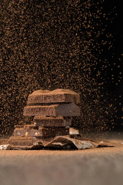 Broken chocolate with sprinkled cocoa — Stock Photo, Image