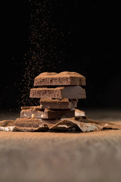 Broken chocolate on bakery paper — Stock Photo, Image