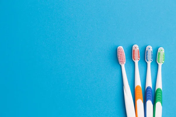 Colorful toothbrushes on blue background — Stock Photo, Image