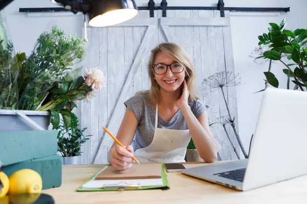 Mujer florista sentada en la mesa — Foto de Stock